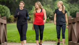 three women walking on bridge